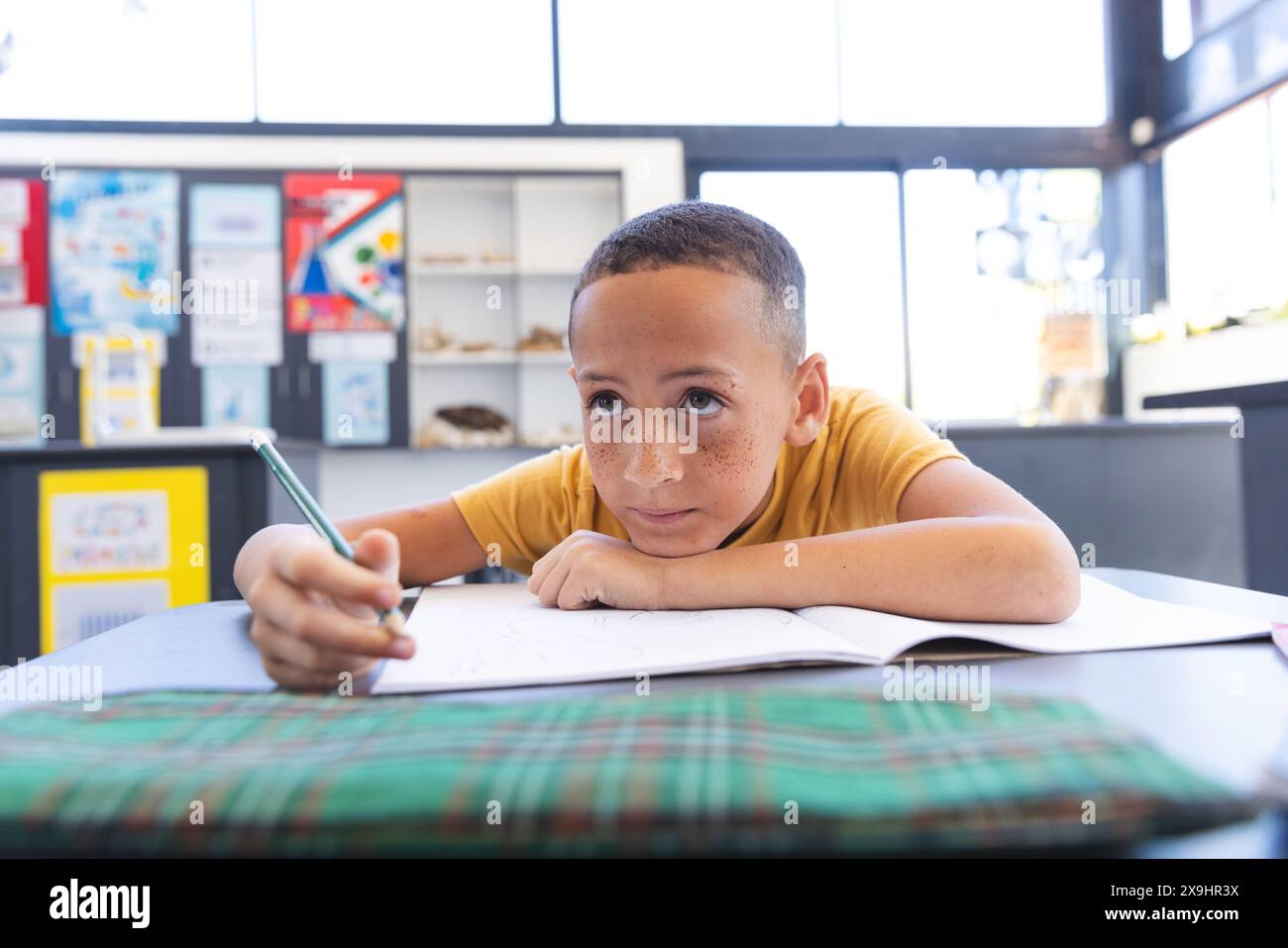 Il ragazzo birazziale si concentra sul suo lavoro scolastico a scuola Foto Stock