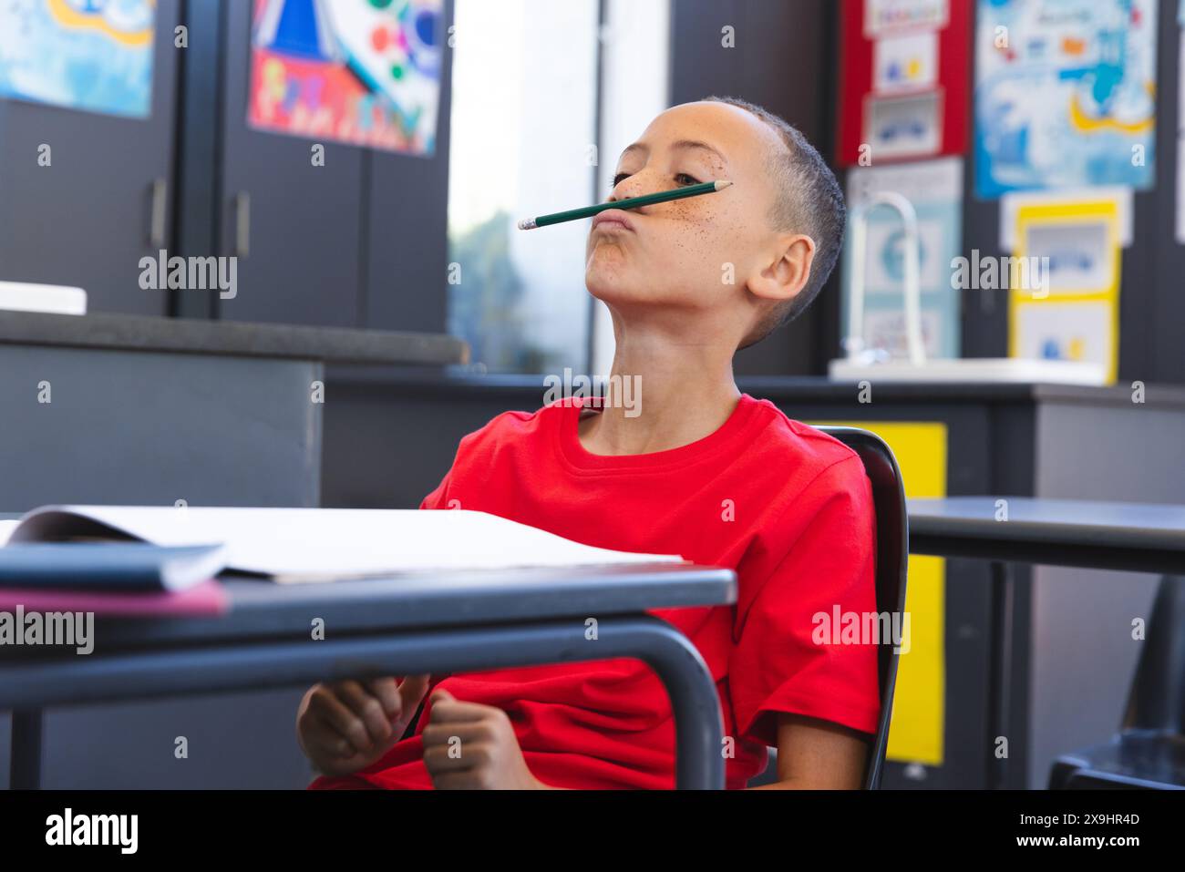 Un ragazzo birazziale si diverte a giocare a scuola Foto Stock