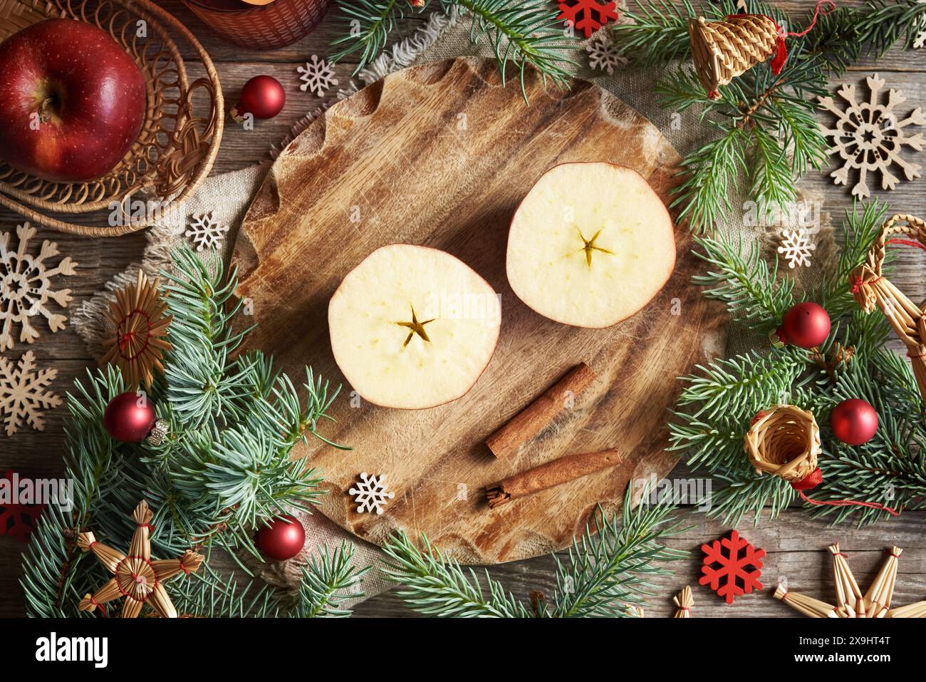 Taglia la mela con una stella al centro con decorazioni e decorazioni di paglia natalizie, vista dall'alto Foto Stock