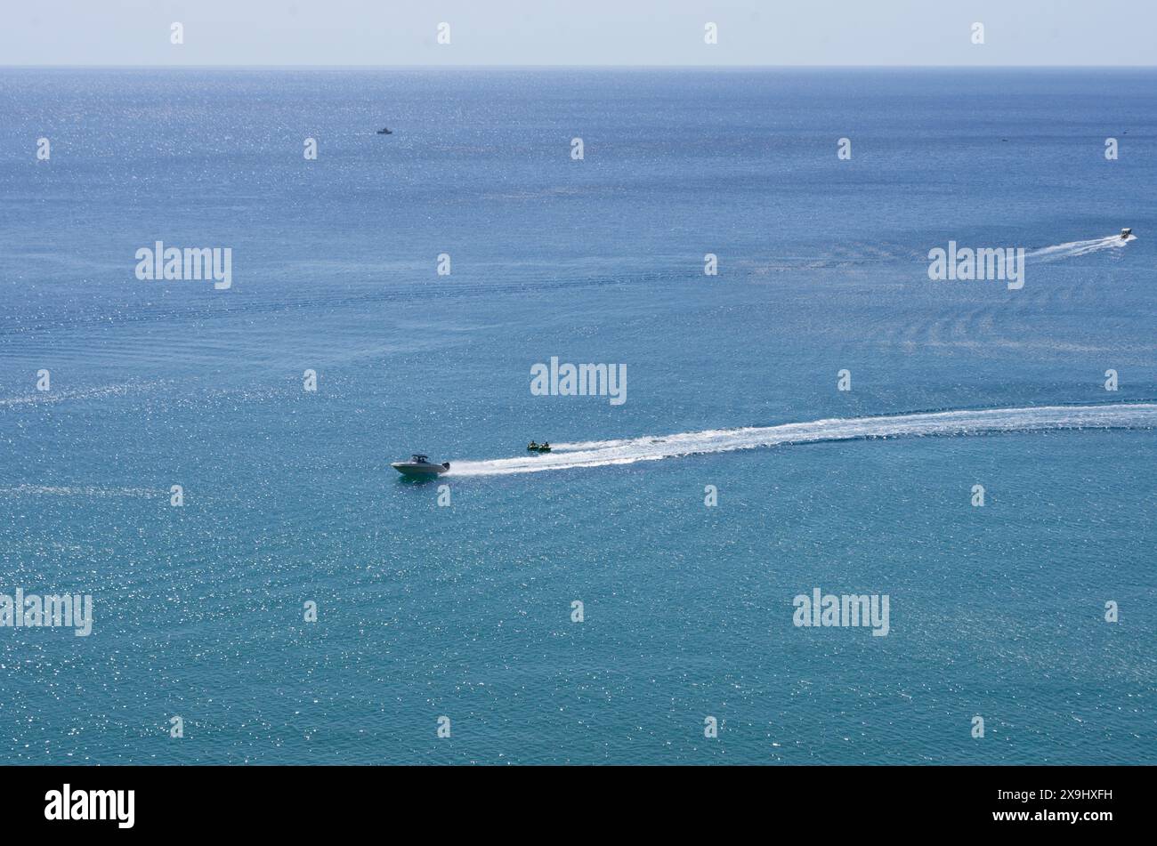 Paesaggio mediterraneo con yacht e turisti impegnati in tubi d'acqua a grande distanza (senza persone e nomi identificabili) (Rodi, Grecia) Foto Stock