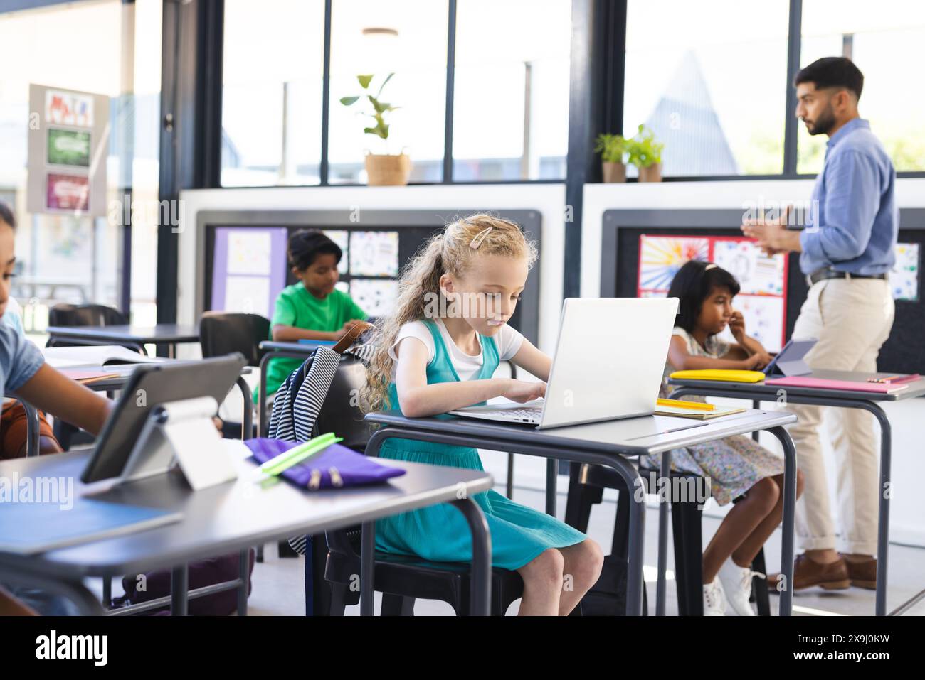 A scuola, diversi gruppi di giovani studenti che si concentrano sui loro studi in classe Foto Stock