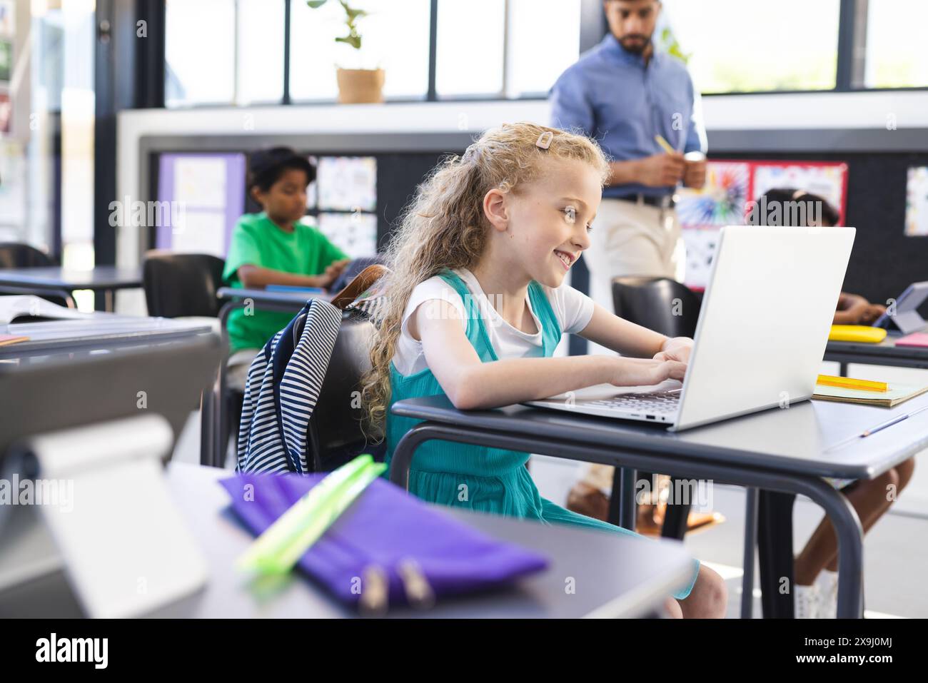 A scuola, gruppi diversi di giovani studenti che si concentrano sui notebook in classe Foto Stock