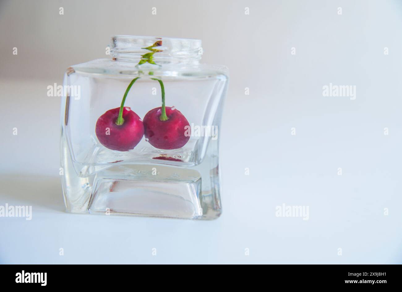 Due le ciliegie in un vaso di vetro. Foto Stock