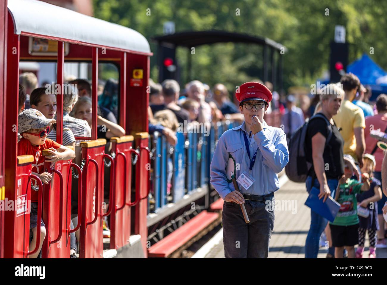 01 giugno 2024, Brandeburgo, Cottbus: Un giovane ferroviere del parco dà il segnale di partenza in occasione del 70° compleanno della ferrovia del parco Cottbus. La ferrovia del parco di Cottbus fu fondata 70 anni fa come ferrovia pioniera. La ferrovia a scartamento ridotto è ancora oggi gestita con l'aiuto di molti bambini e giovani; le sette locomotive e le numerose carrozze corrono da aprile a ottobre su un binario di 3,2 chilometri. Foto: Frank Hammerschmidt/dpa/ZB Foto Stock