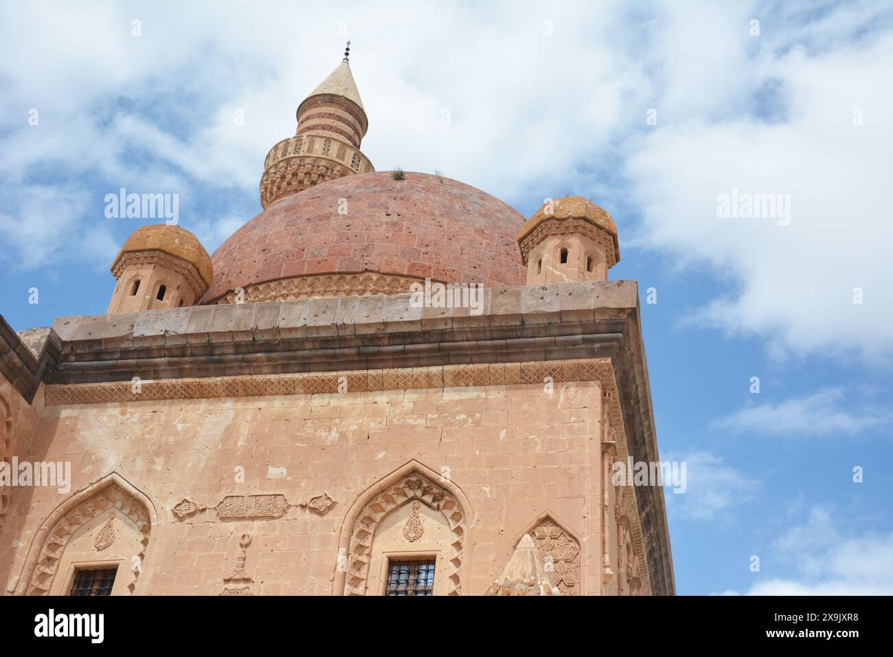 Vecchio edificio islamico o moschea con una cupola in cima e versi del Corano arabo, su sfondo cielo blu. palazzo ishak pasha ad agri, turchia. Foto Stock