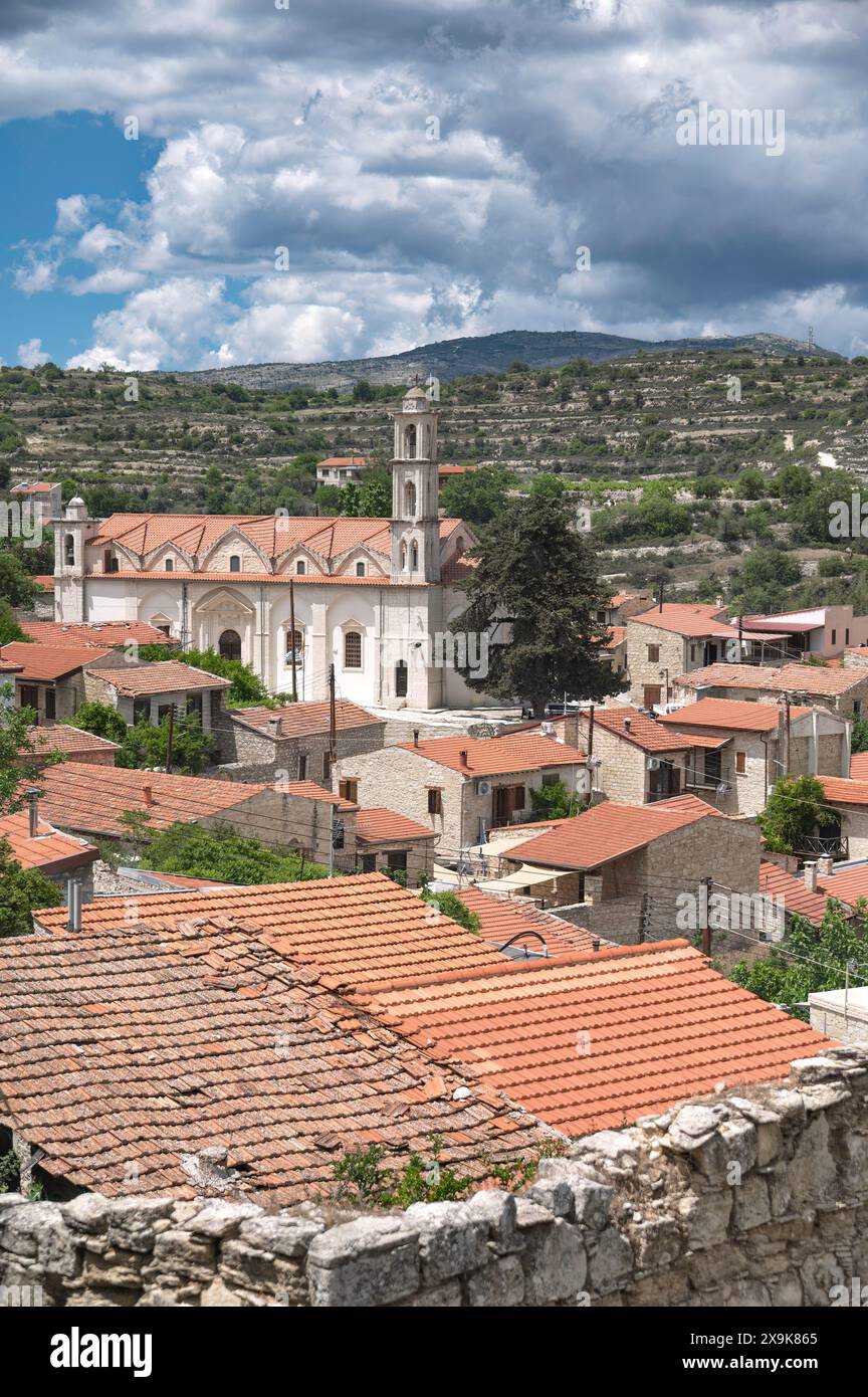 Vista panoramica di un pittoresco villaggio di Lofou con chiesa architettonica e tetti in terracotta contro un cielo nuvoloso. Distretto di Limassol, Cipro Foto Stock