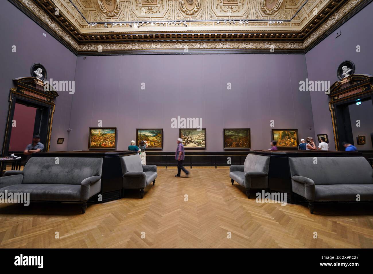 Interno del museo d'arte. I visitatori che guardano i dipinti sulle pareti in una sala viola con divani all'interno del museo di storia dell'arte di Vienna Kunsthistorisches o KHM Foto Stock