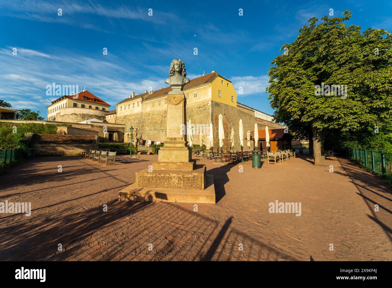 Fortezza del castello di Špilberk, terreni a Brno, Cechia con una statua e caffetteria all'aperto in una giornata di sole senza persone. Un castello storico ora museo cittadino. Foto Stock