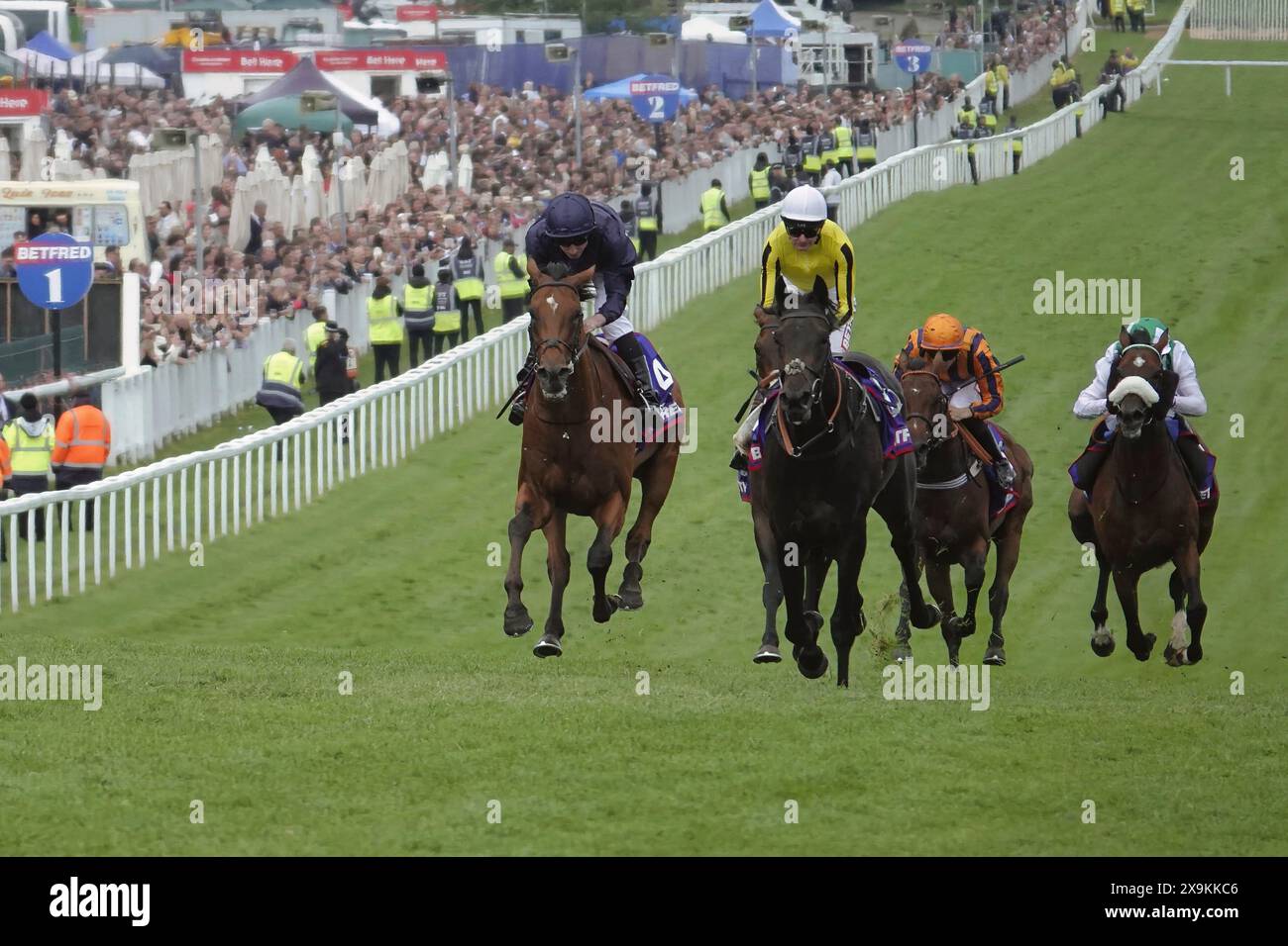 Epsom, Surrey, Regno Unito. 1 giugno 2024. La città di Troia (L), con Ryan Moore (colori blu scuro) su, sali la collina sul rettilineo principale del Betfred Derby, corri per oltre un chilometro e quattro volte sull'iconico ippodromo di Epsom Downs. Crediti: Motofoto/Alamy Live News Foto Stock