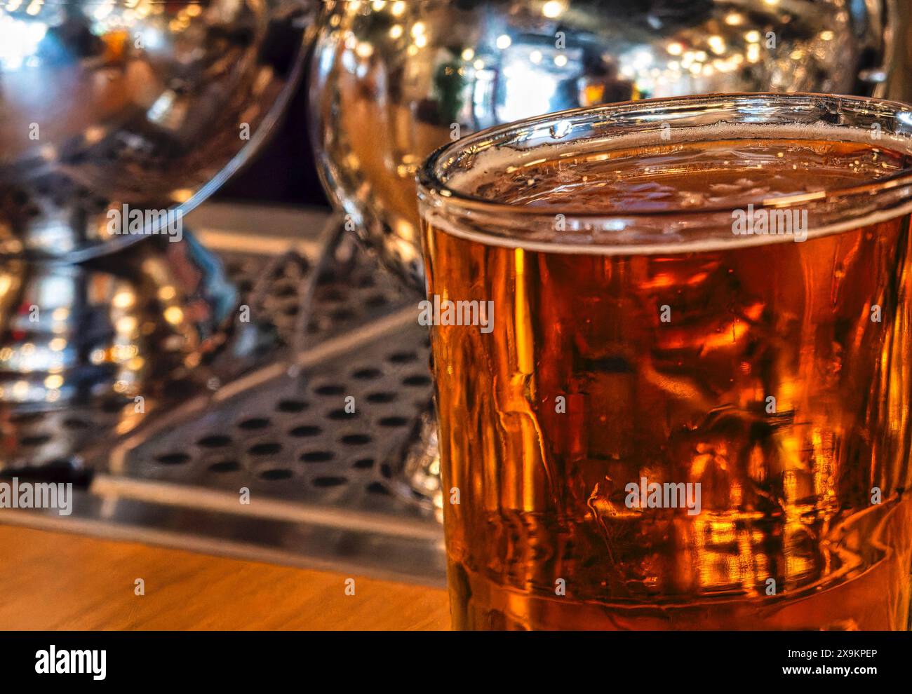Una pinta di lager si illumina sulla parte superiore di un bar Foto Stock