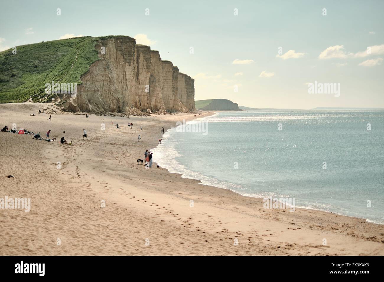 Gente a East Beach, chiamata anche East Cliff Beach, sotto le East Cliffs a West Bay, Dorset in una giornata estiva di sole. Foto Stock