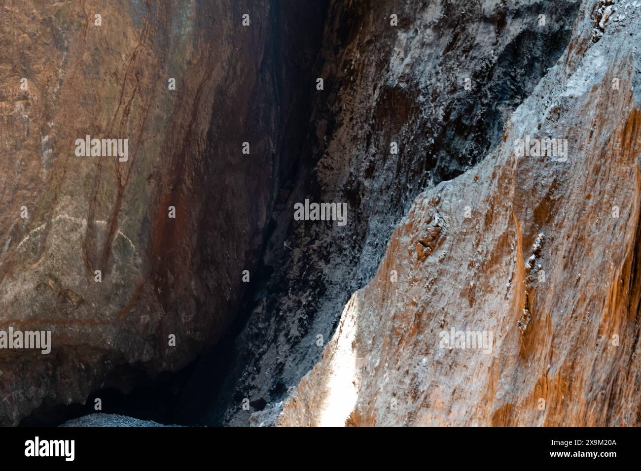 Esplora le profondità mistiche di questa grotta baciata dal sole, dove ti attendono antichi segreti in mezzo all'abbraccio roccioso. Foto Stock