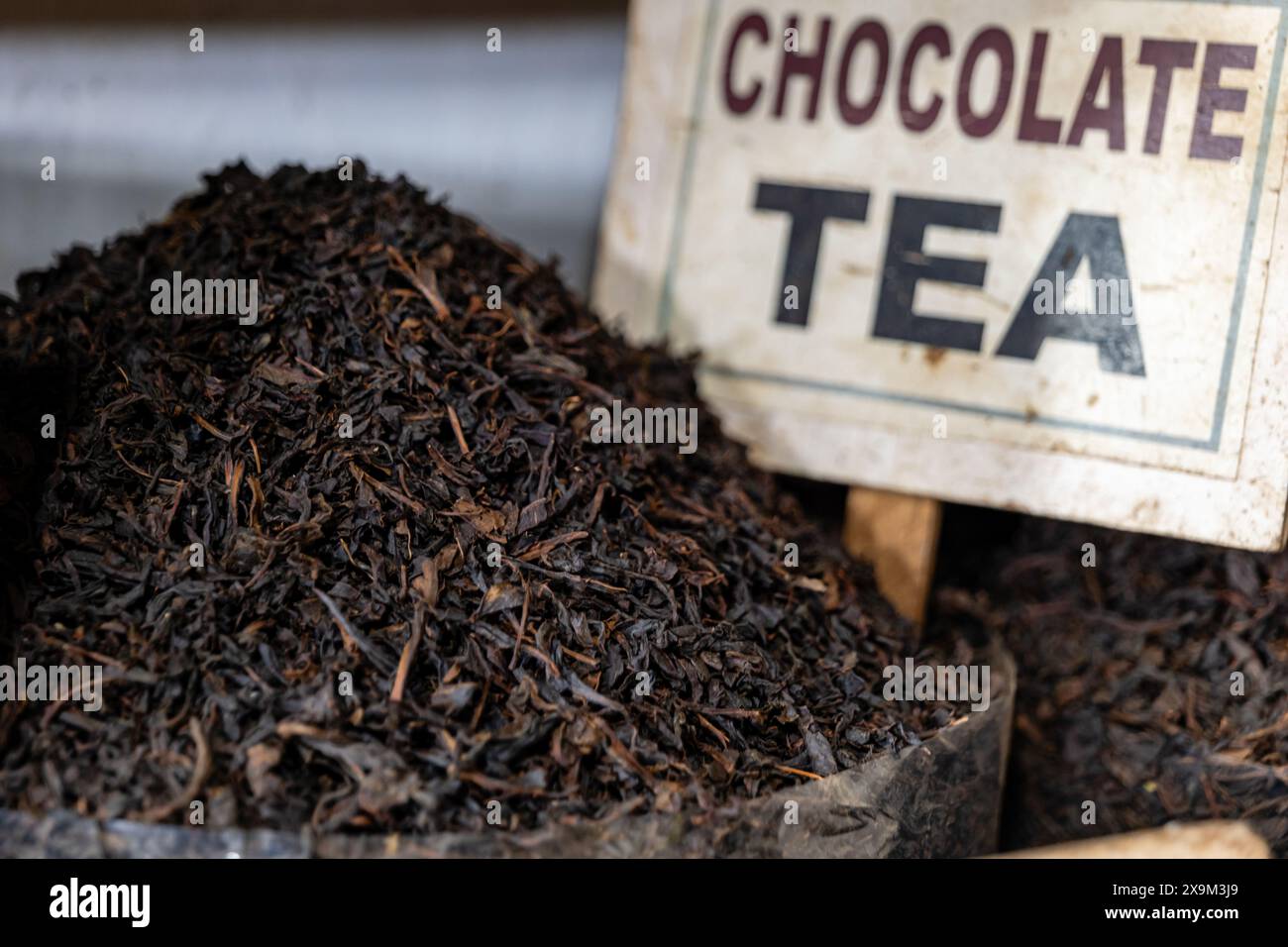 Un primo piano di ricche foglie di tè al cioccolato, promettendo una deliziosa miscela di sapori Foto Stock