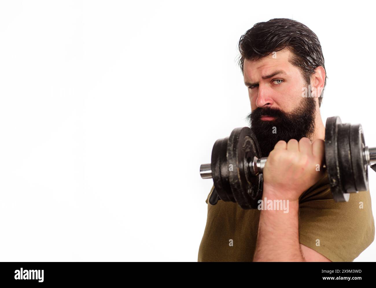 Uomo barbuto che solleva il manubrio in palestra. Stile di vita sportivo sano e concetto di fitness. Modello atletico maschile di fitness rialzato manubrio. Metti il bell'uomo in sp Foto Stock