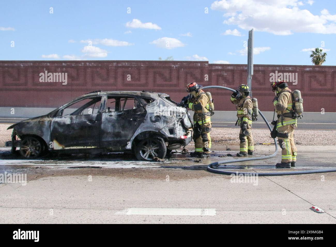 Un'auto che scoppiò in fiamme viene spenta da Mesa Fire and Medical StationÕs 220 e 205 lungo la US 60 direzione est vicino allo svincolo 202 a Mesa, Ariz Foto Stock