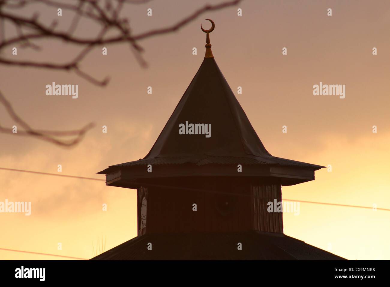Silhouette di una cupola moschea con una mezzaluna al tramonto Foto Stock
