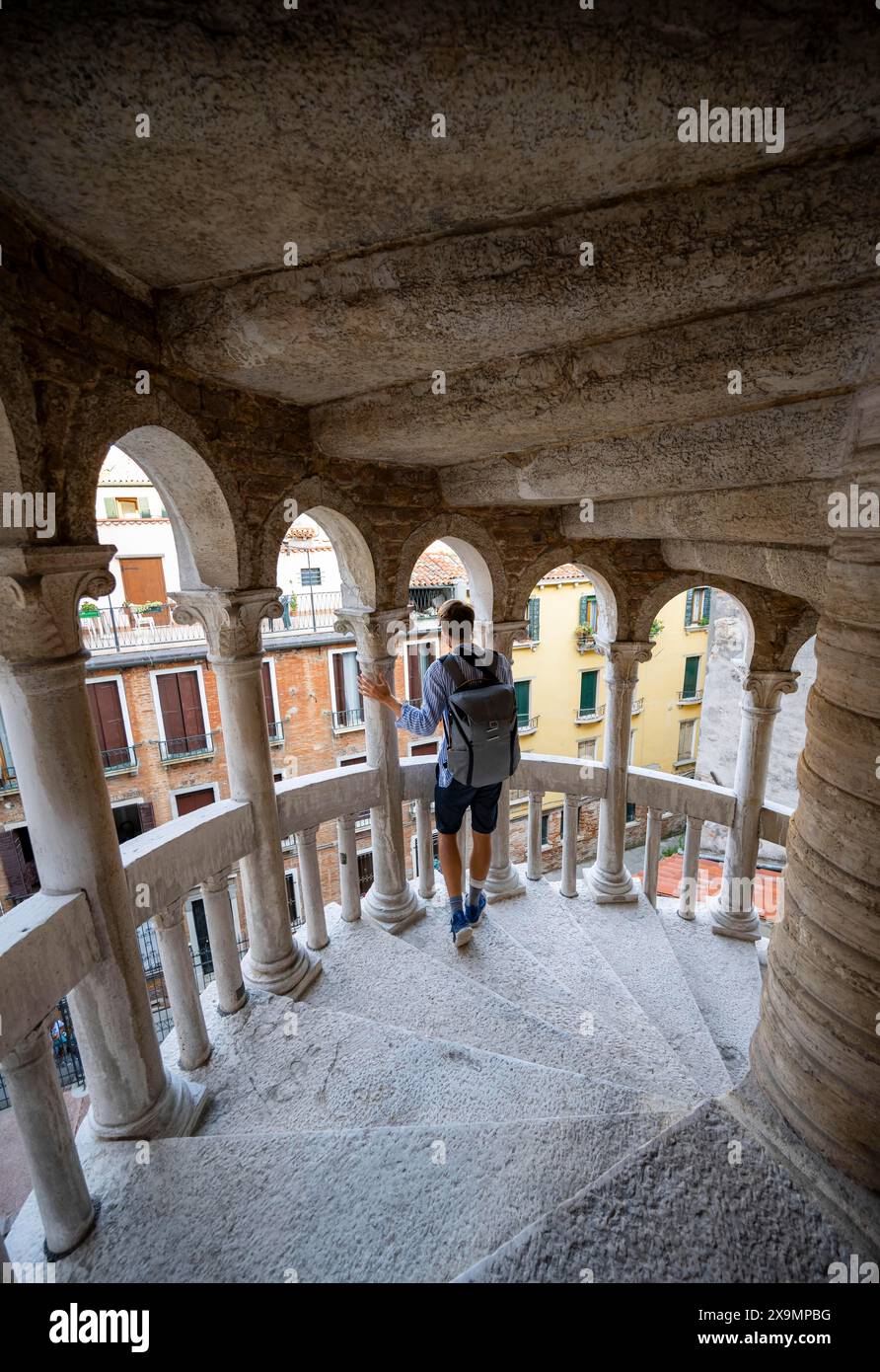 Giovane sulla scala a chiocciola Palazzo Contarini del Bovolo, Palazzo con scala a chiocciola, Venezia, Veneto, Italia Foto Stock