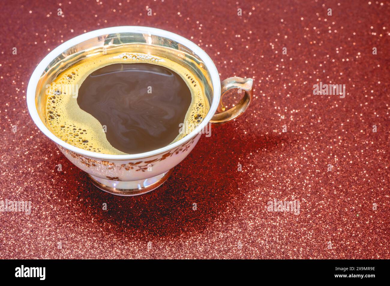 Caffè in una tazza elegante e sfondo rosso. Foto Stock