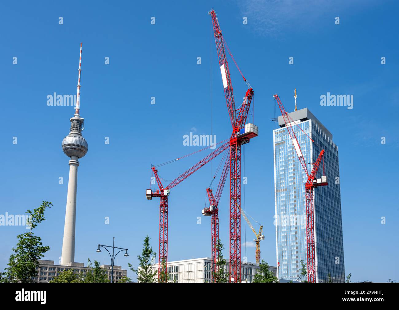La famosa torre della televisione di Berlino con gru a torre rosse Foto Stock