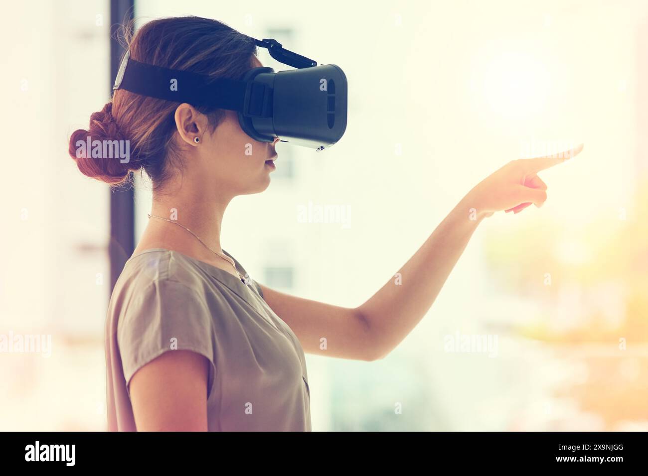 Realtà aumentata, donna e puntamento con visore VR, tecnologia e scelta sul posto di lavoro. Assistente virtuale femminile, high tech e selezione in ufficio Foto Stock