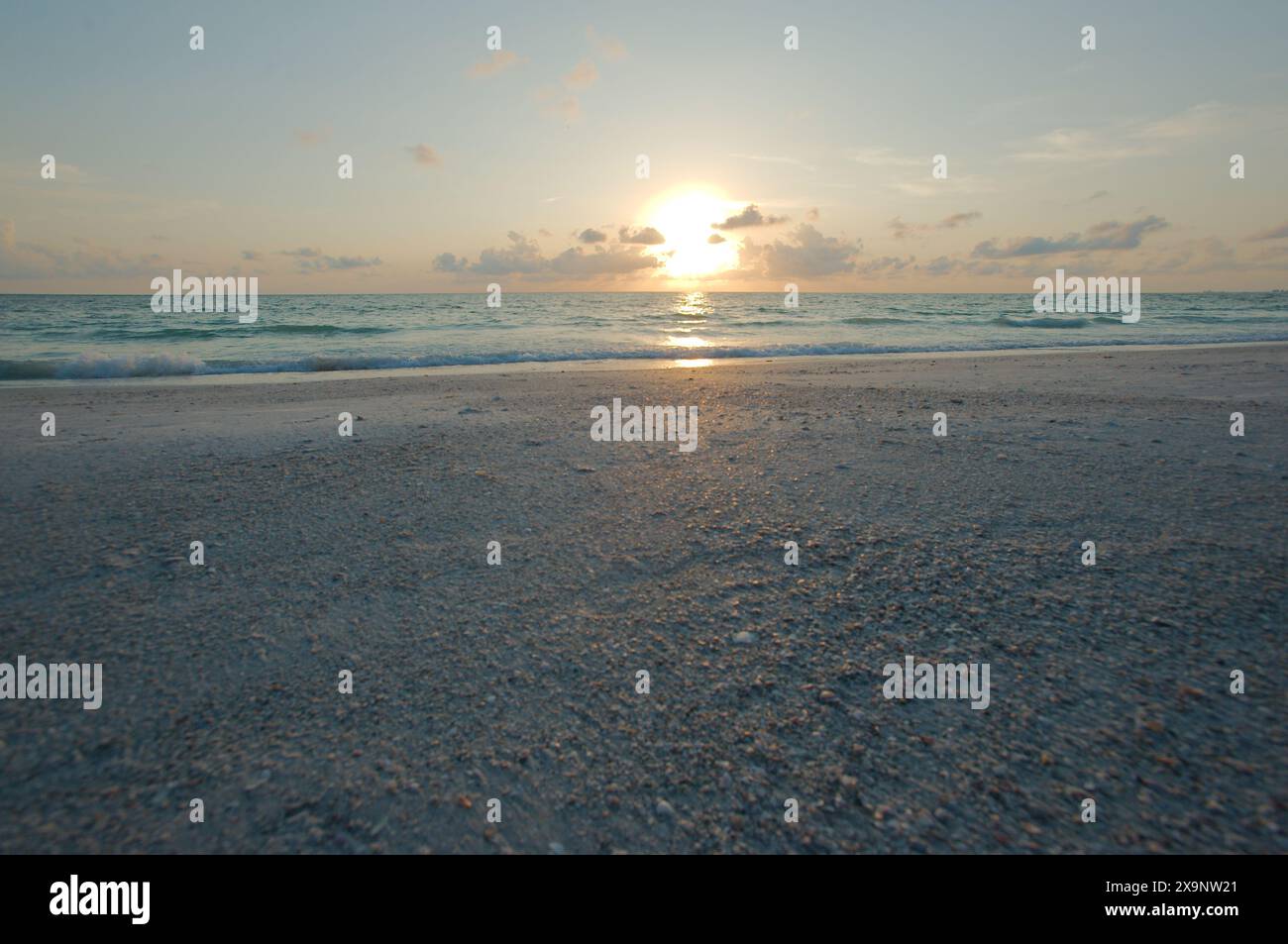 Ampia vista della spiaggia Pass-a-Grille di St. Pete Beach, Florida, guardando a nord-ovest. Ampia sabbia e onde in acqua, vicino al tramonto con acqua blu Foto Stock