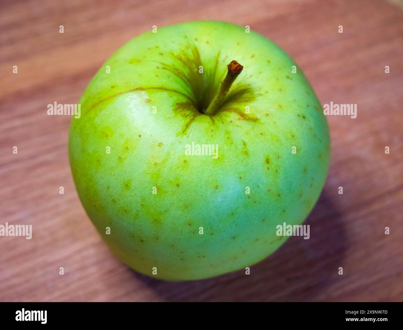 Immagine luminosa di una singola mela, che suggerisce semplicità e concentrazione su un'alimentazione sana. Foto Stock