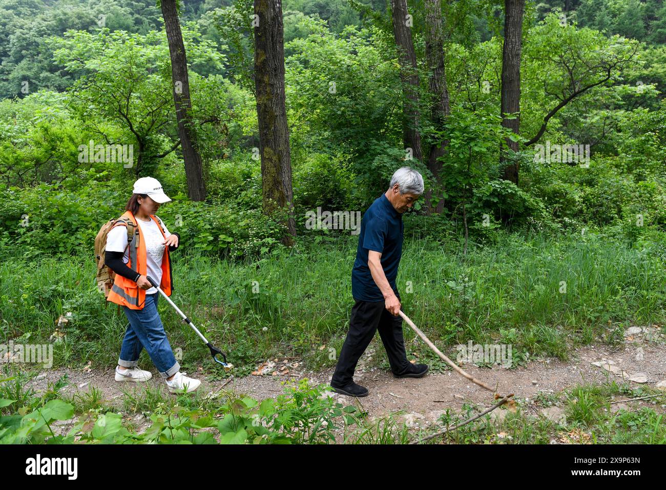 (240602) -- PECHINO, 2 giugno 2024 (Xinhua) -- Mei Jingtian (R) e Liu Hongyan stanno andando a pattugliare la grande Muraglia nel villaggio di Shixia nel distretto di Yanqing di Pechino, capitale della Cina, 23 maggio 2024. Mei ha iniziato a proteggere la grande Muraglia spontaneamente dai primi anni '1980 e ha aumentato la consapevolezza della protezione della grande Muraglia tra molti abitanti del villaggio. Il villaggio di Shixia nel distretto di Yanqing di Pechino fu costruito per la prima volta durante la dinastia Ming (1368-1644) e un tempo era un importante passo nel nord della sezione di Juyongguan della grande Muraglia. Il villaggio, circondato da montagne, ha sviluppato un to Foto Stock