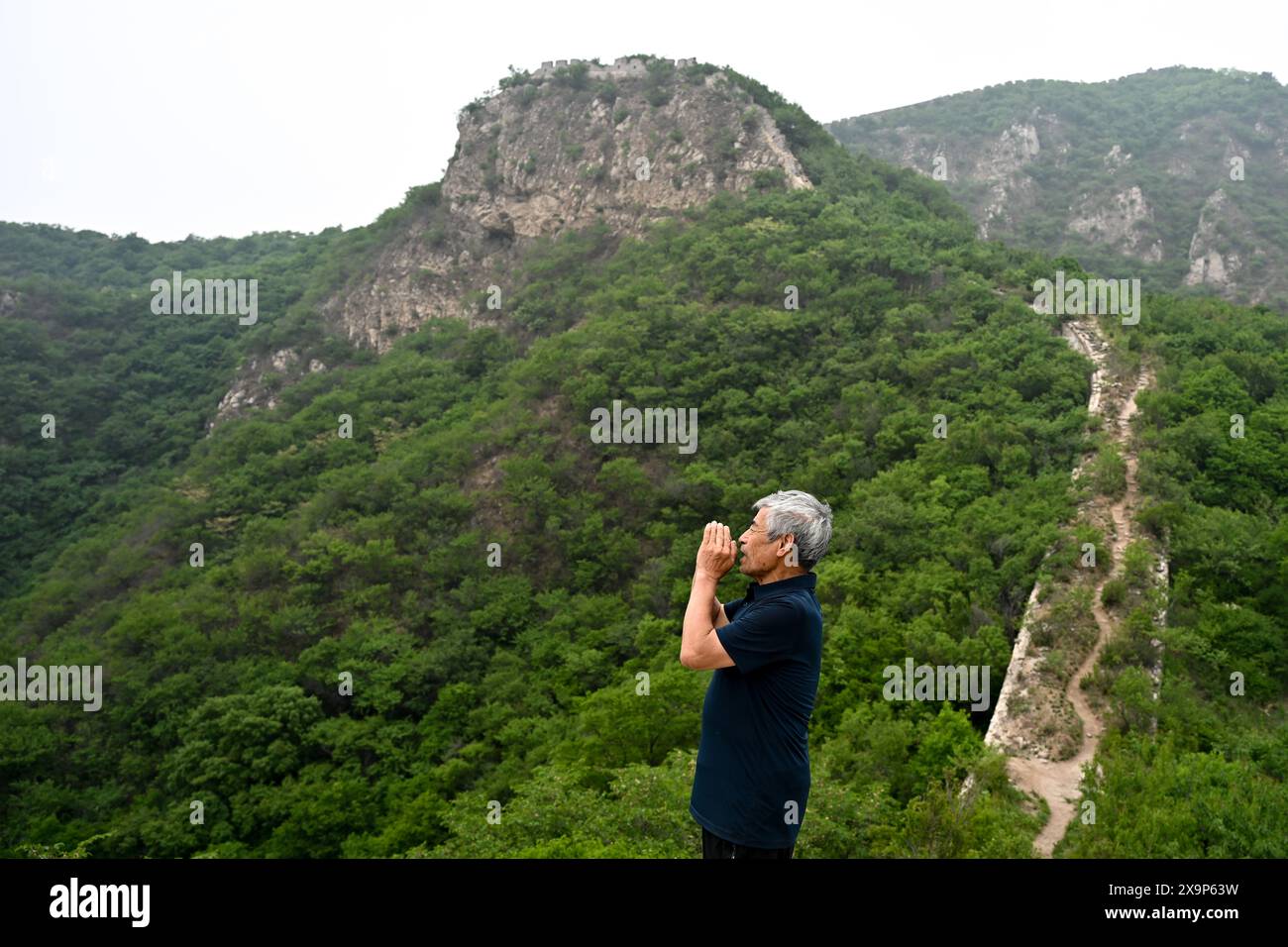 (240602) -- PECHINO, 2 giugno 2024 (Xinhua) -- Mei Jingtian, un protettore della grande Muraglia di 80 anni, è visto sulla grande Muraglia nel villaggio di Shixia nel distretto di Yanqing di Pechino, capitale della Cina, 23 maggio 2024. Mei ha iniziato a proteggere la grande Muraglia spontaneamente dai primi anni '1980 e ha aumentato la consapevolezza della protezione della grande Muraglia tra molti abitanti del villaggio. Il villaggio di Shixia nel distretto di Yanqing di Pechino fu costruito per la prima volta durante la dinastia Ming (1368-1644) e un tempo era un importante passo nel nord della sezione di Juyongguan della grande Muraglia. Il villaggio, circondato da montagne, ha sviluppato un Foto Stock
