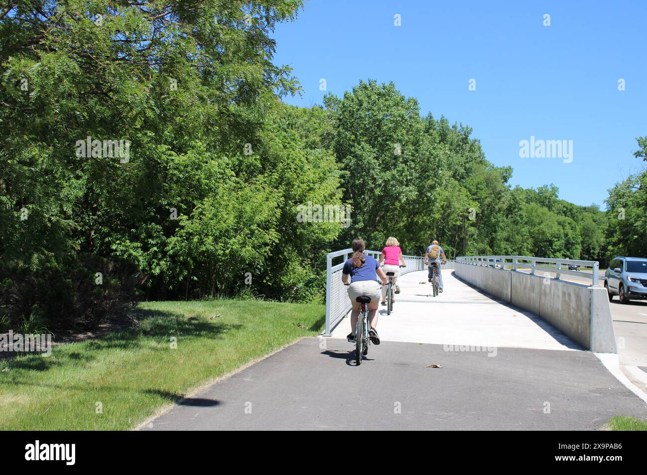 Tre ciclisti sul sentiero laterale di Oakton Street a Des Plaines, Illinois Foto Stock