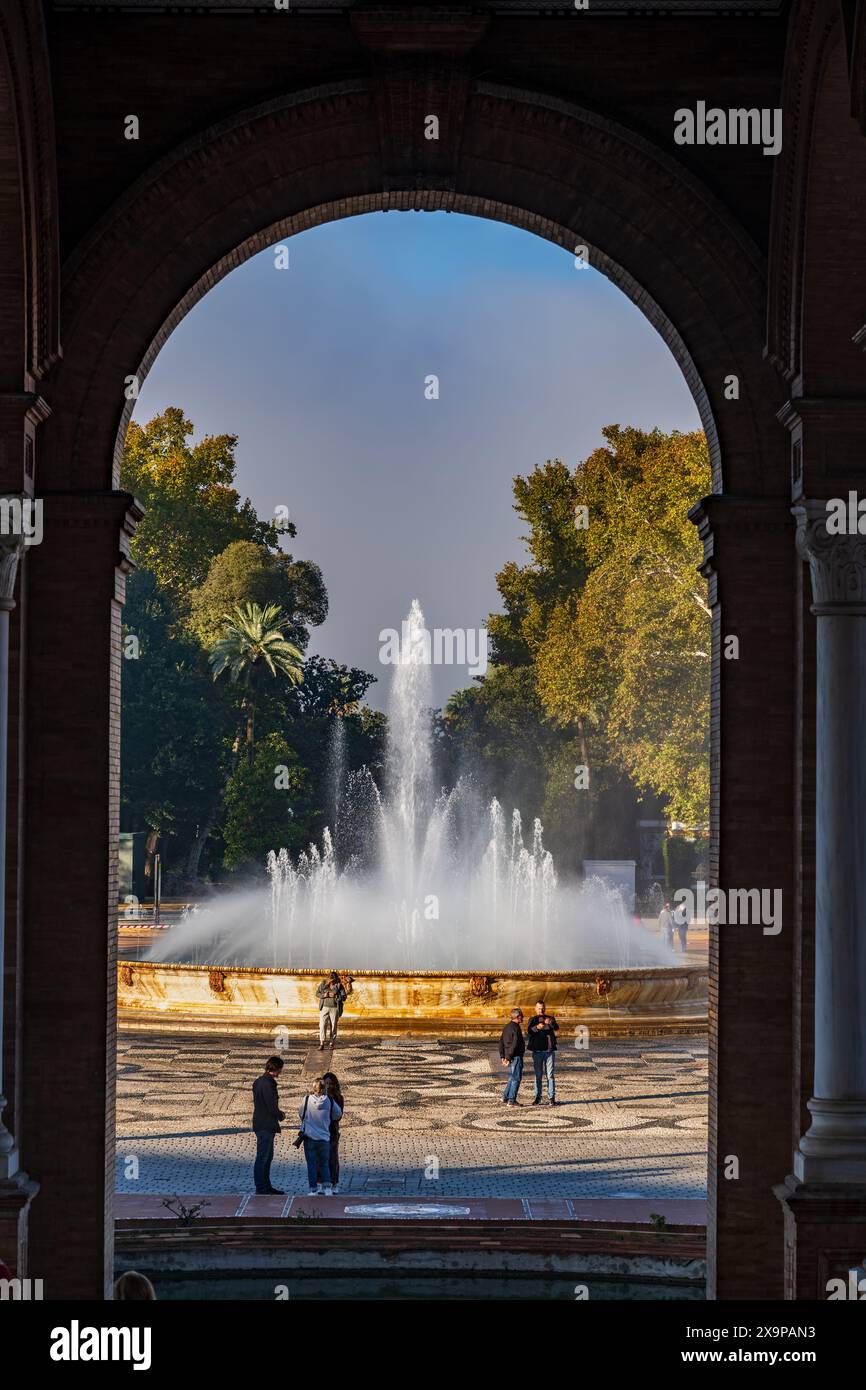 Siviglia, Andalusia, Spagna - 24 ottobre 2023 - Fontana in piazza Plaza de Espana nel Parco Maria Luisa, incorniciata da un arco di padiglione. Foto Stock