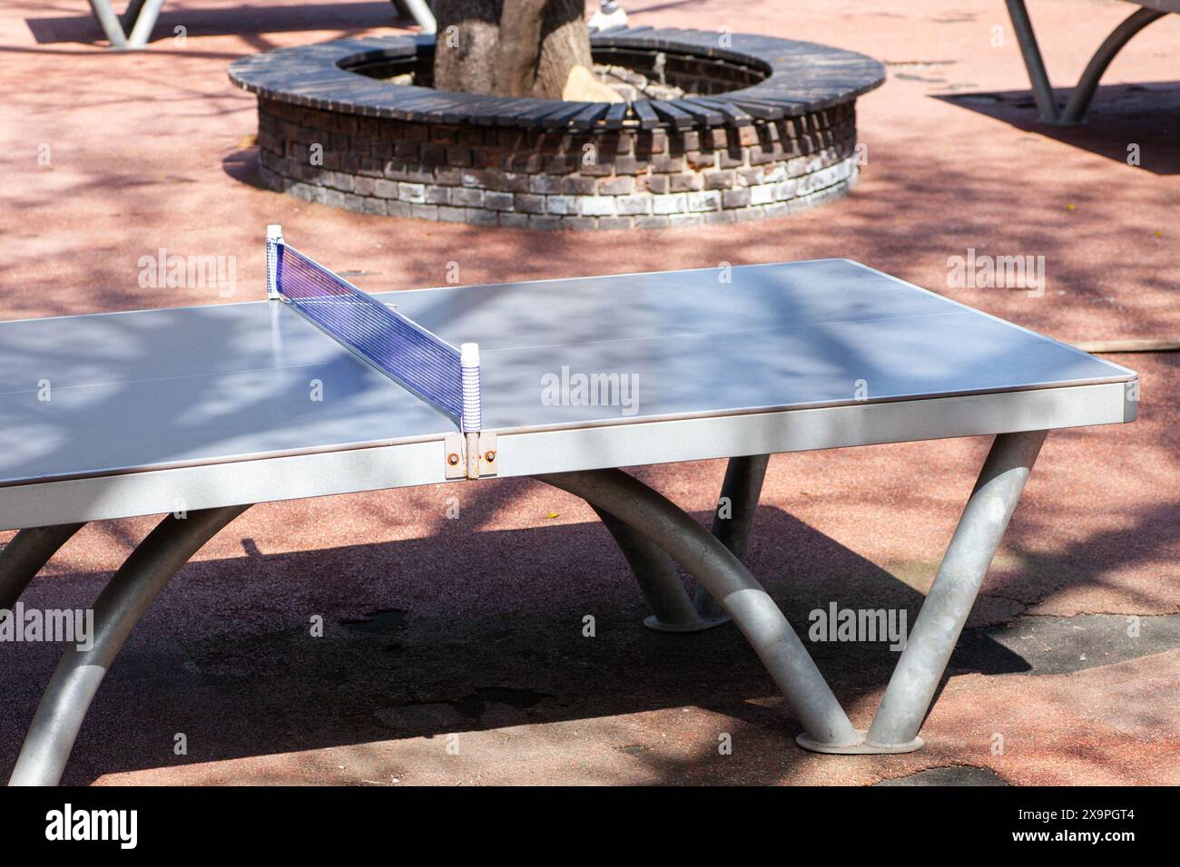 Tavolo da ping pong all'aperto in un parco soleggiato, pronto per una partita Foto Stock