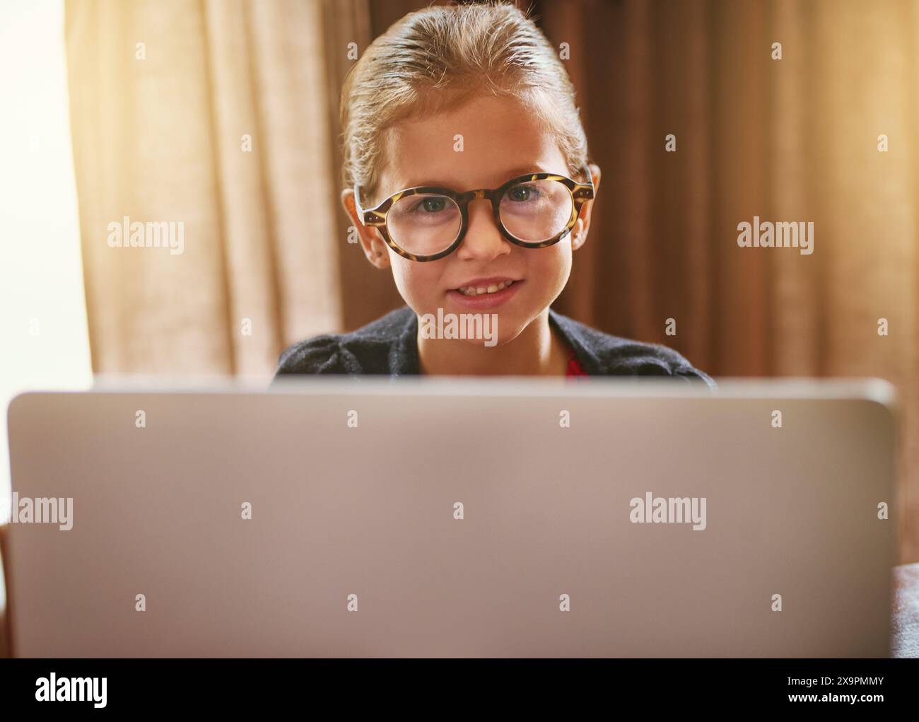 Scuola materna, bambino e apprendimento con notebook a casa con la felicità di studiare nell'istruzione online. Eccitato, bambino e ritratto al computer con corso di intelligenza artificiale Foto Stock