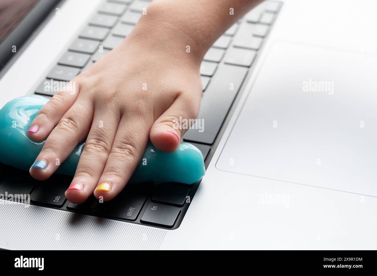 Eliminare la polvere dalla tastiera del computer con una vista ravvicinata adesiva Foto Stock