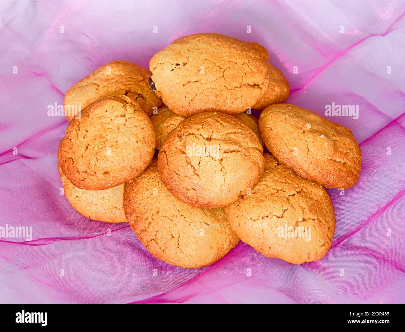 Biscotti dorati su sfondo rosa Foto Stock