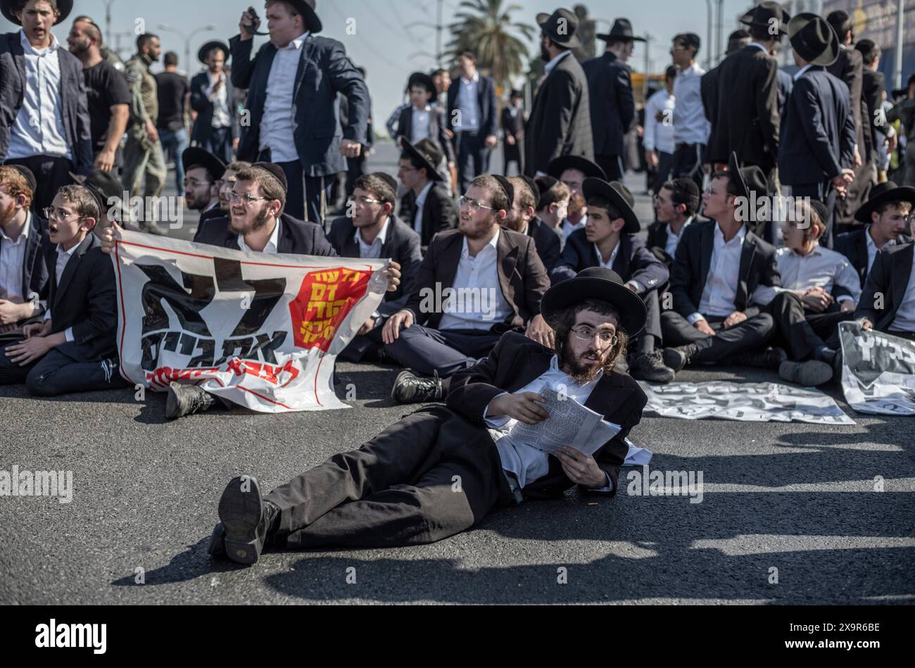 Bnei Brak, Israele. 2 giugno 2024. I manifestanti ebrei ultra-ortodossi bloccano una strada a Bnei Brak, durante una protesta contro possibili cambiamenti nelle leggi esentano gli uomini ultra-ortodossi dalla coscrizione militare. Crediti: Ilia Yefimovich/dpa/Alamy Live News Foto Stock