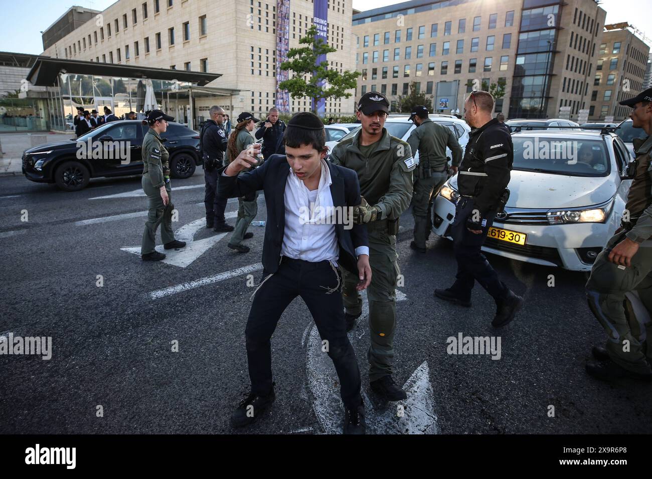 La polizia DI PROTESTA DI DIFESA ISRAELIANA MIDEAST rimuove gli ebrei ultra-ortodossi che bloccano una strada durante una protesta contro la coscrizione militare al di fuori della Corte suprema israeliana a Gerusalemme, 2 giugno 2024. La Corte Suprema d'Israele ascolta il 2 giugno una risposta dello stato sulla questione del reclutamento ultra ortodosso, dopo aver precedentemente prorogato un termine per la presentazione da parte del governo di un piano di coscrizione per gli ebrei ultra-ortodossi, che sono tradizionalmente esenti dal servizio militare. Foto di saeed qaq Copyright: XSAEEDQAQx AX4X1975 Foto Stock
