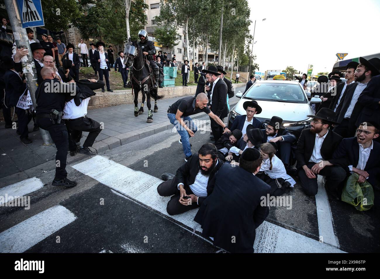 La polizia DI PROTESTA DI DIFESA ISRAELIANA MIDEAST rimuove gli ebrei ultra-ortodossi che bloccano una strada durante una protesta contro la coscrizione militare al di fuori della Corte suprema israeliana a Gerusalemme, 2 giugno 2024. La Corte Suprema d'Israele ascolta il 2 giugno una risposta dello stato sulla questione del reclutamento ultra ortodosso, dopo aver precedentemente prorogato un termine per la presentazione da parte del governo di un piano di coscrizione per gli ebrei ultra-ortodossi, che sono tradizionalmente esenti dal servizio militare. Foto di saeed qaq Copyright: XSAEEDQAQx AX4X2597 Foto Stock