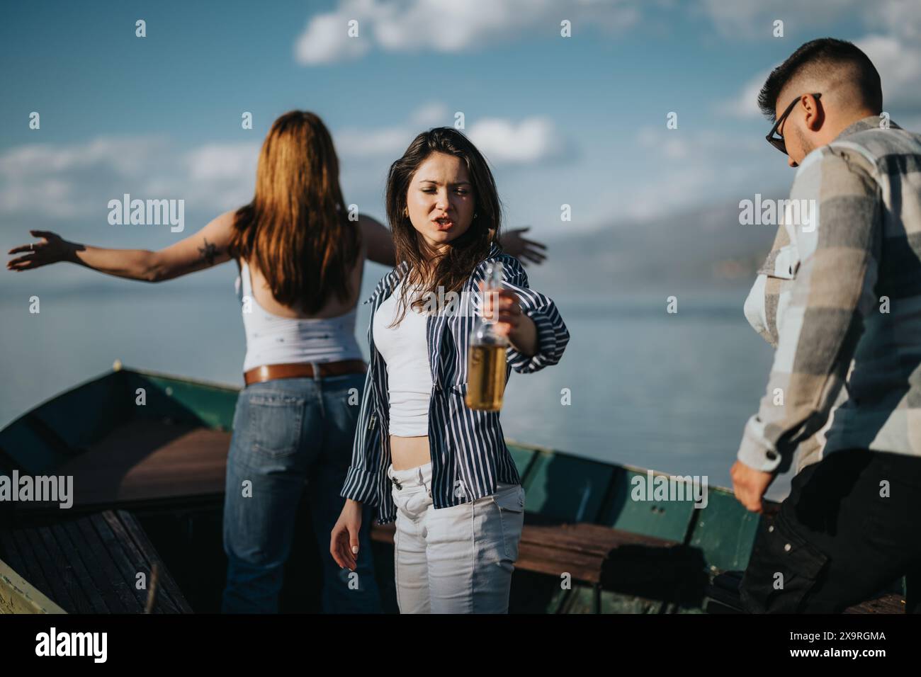Giovani amici che condividono le risate in una giornata di sole in riva al lago, catturando momenti di divertimento e divertimento all'aria aperta Foto Stock