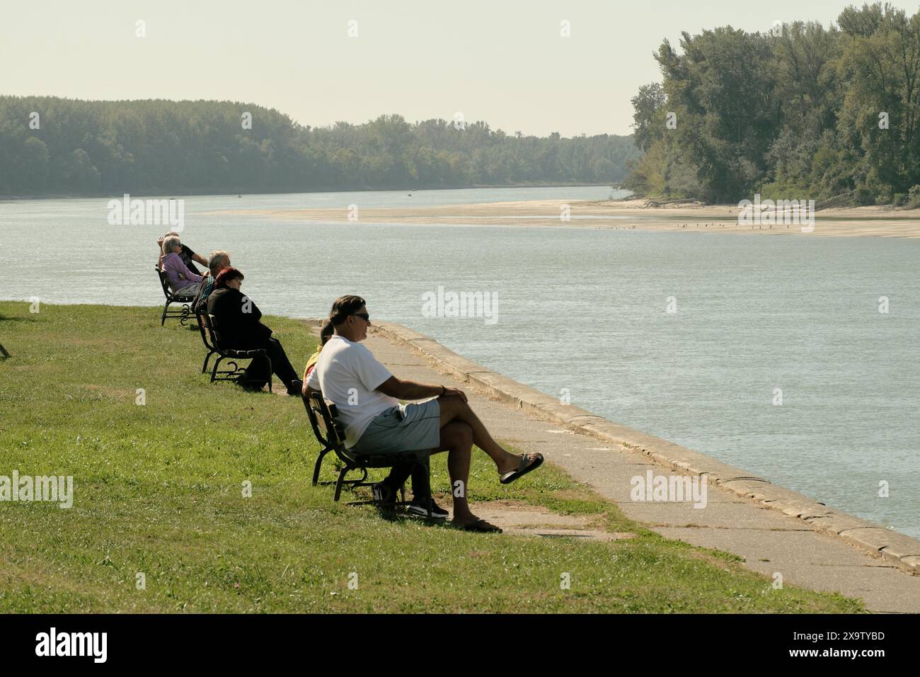 Persone sedute sulle panchine sul Danubio ad Apatin, Vojvodina, Serbia Foto Stock
