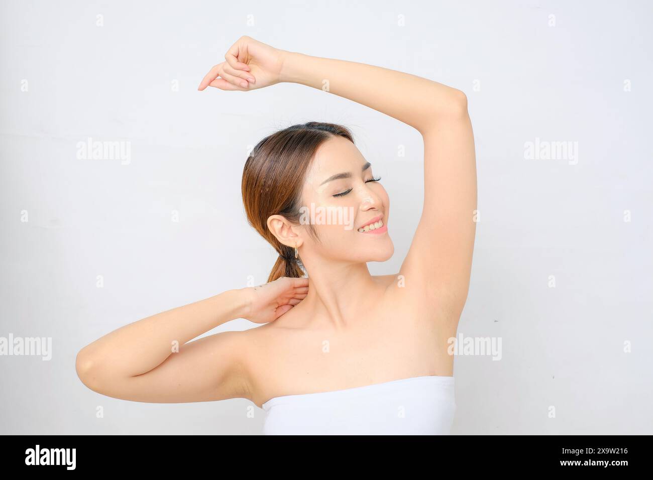 Donna asiatica che si gode il suo piacevole profumo ascellare Foto Stock