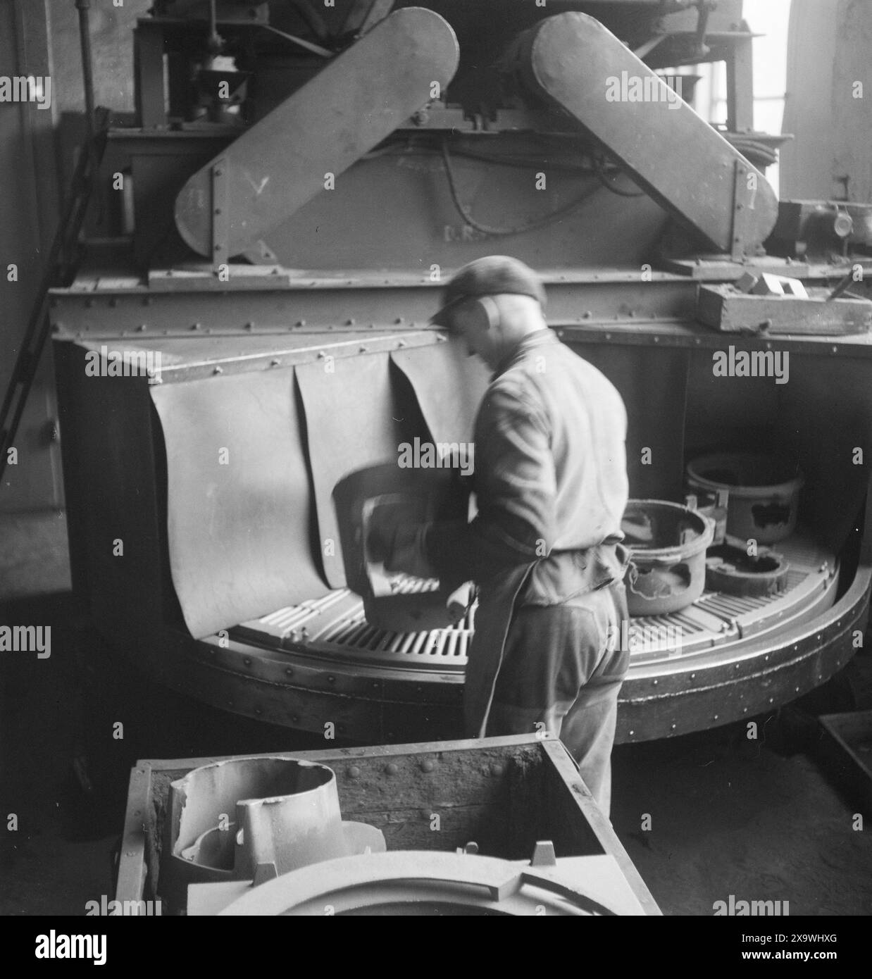 Effettivo 21-1946: Fonderia di ferro di Drammen. Qui i forni finiti sono allineati in formazioni pulite. Si dirigono tutti a nord verso Finnmark e Nord-Troms e saranno buone truppe nella seconda "battaglia invernale" per il ritorno dei tedeschi in questa parte devastata del paese. Si può solo sperare che non debbano aspettare a lungo per il trasporto. L'inverno Finnmark non vede l'ora! Secondo un incarico, 5.000 stufe erano scomparse all'inizio di settembre e 10.000 solo per l'insediamento provvisorio eretto in questa guerra, devastarono i distretti. I forni fusi sono piuttosto "impuri" Foto Stock