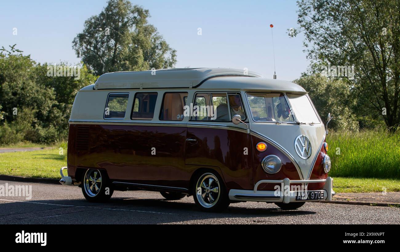 Stony Stratford, Regno Unito - 2 giugno 2024: Camper Volkswagen Maroon 1967 con guida a schermo diviso su una strada di campagna britannica Foto Stock