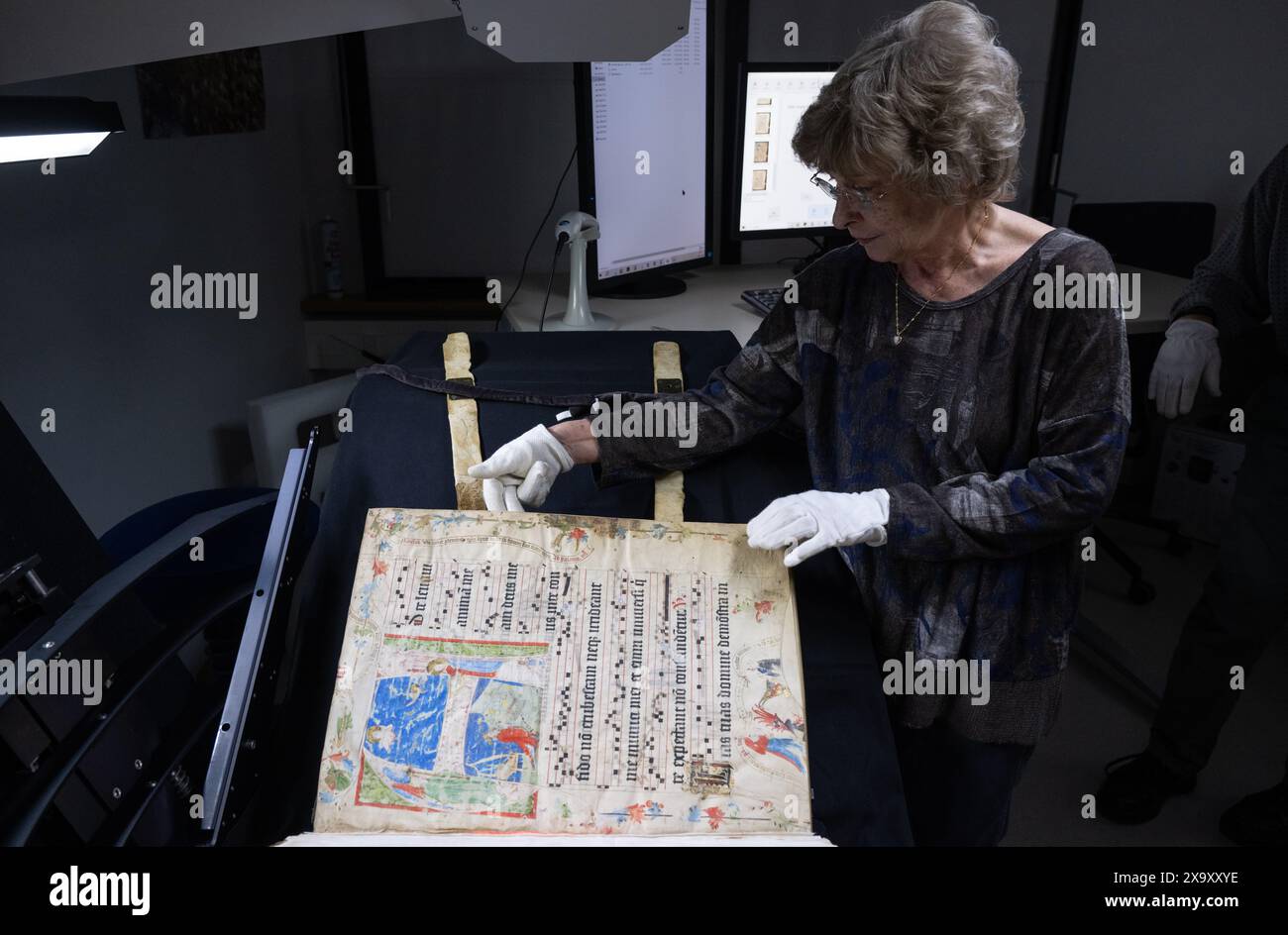 Mainz, Germania. 29 maggio 2024. Bettina Dreis allinea un libro di coro storico del Medioevo sotto uno speciale scanner con precisione millimetrica. Il dispositivo digitalizza il libro con l'aiuto di una fotocamera digitale ad alta risoluzione. Credito: Boris Roessler/dpa/Alamy Live News Foto Stock