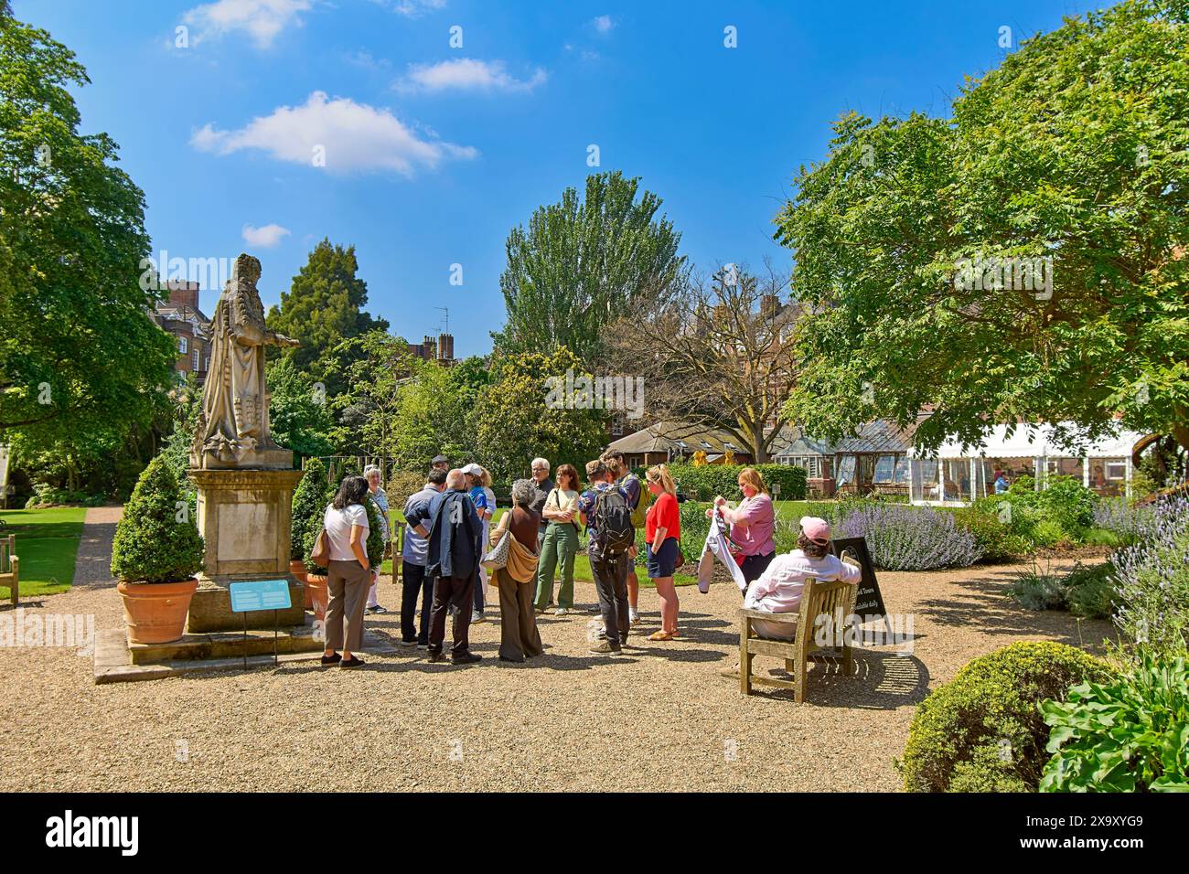 Chelsea Physic Garden cielo blu sopra il gruppo di turisti accanto alla statua di Hans Sloane Foto Stock