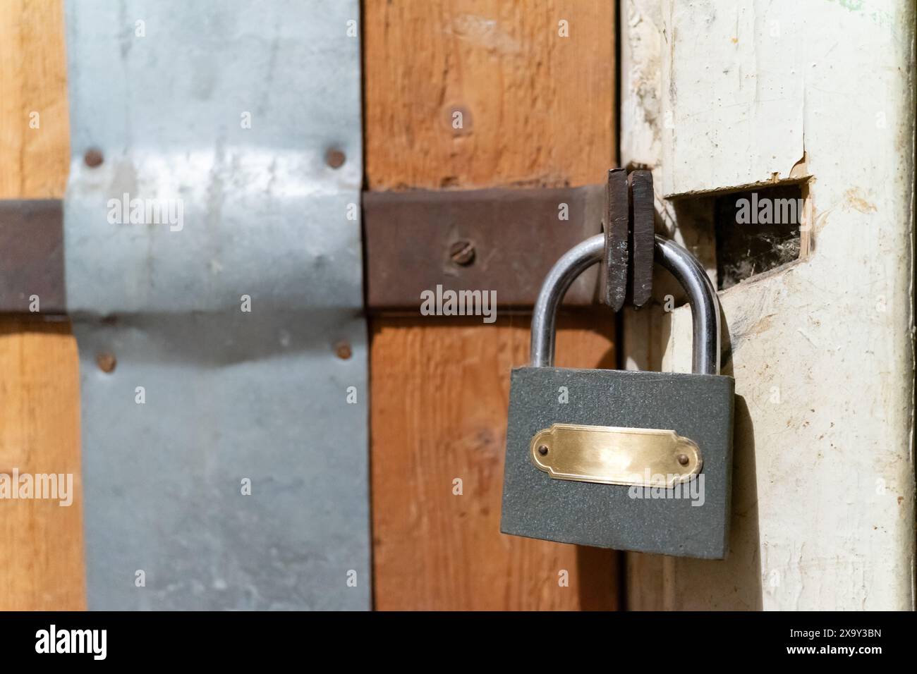 Una porta di legno chiusa con una piccola serratura di metallo. Foto Stock