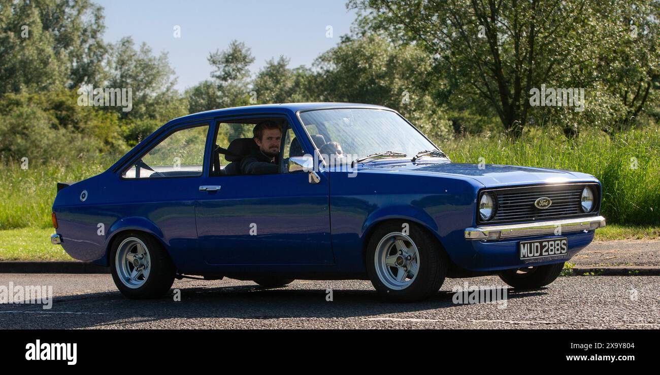 Stony Stratford, Regno Unito - 2 giugno 2024: 1978 auto Ford Escort gl blu che guida su una strada di campagna britannica Foto Stock