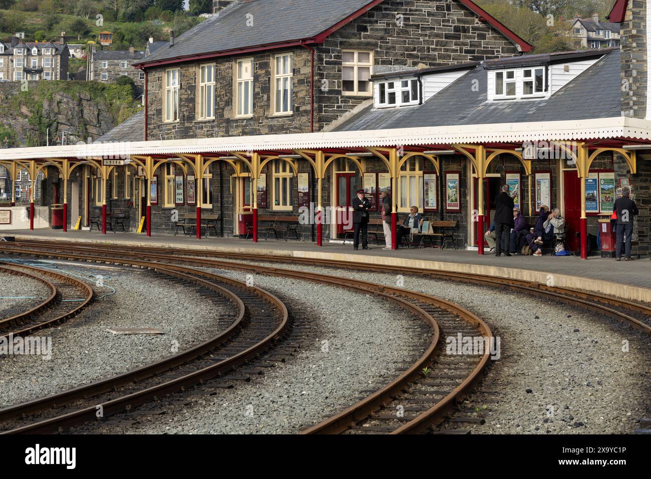 Passeggeri e un membro del personale della stazione di Porthmadog, Welsh Highland Heritage Railway. Porthmadog, Gwynedd, Galles Foto Stock