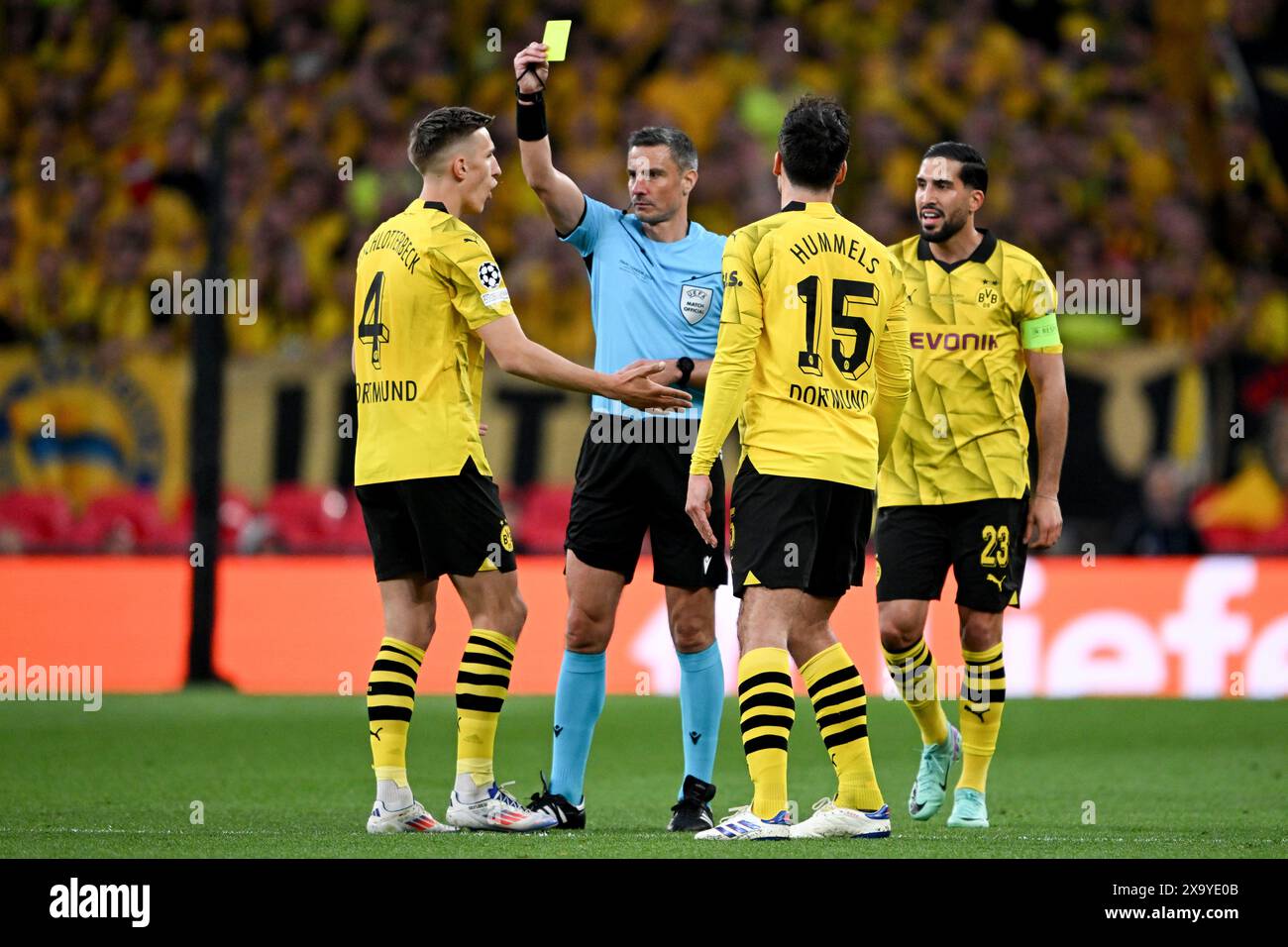 01 giugno 2024, Regno Unito, Londres;: La finale di Champions League tra Borussia Dortmund e Real Madrid allo stadio di Wembley di sabato ha visto una prova della nuova regola secondo cui solo il capitano di ogni squadra può rivolgersi all'arbitro, che verrà applicata durante il Campionato europeo in Germania. Nella foto, l'arbitro della finale di Wembley, lo sloveno Slavko Vincic, mostra il cartellino giallo all'internazionale Nico Schlotterbeck, per aver protestato, alla presenza del compagno di squadra Mats Hummels e del capitano tedesco Emre CAN. Foto: Robert Michael/dpa Foto Stock