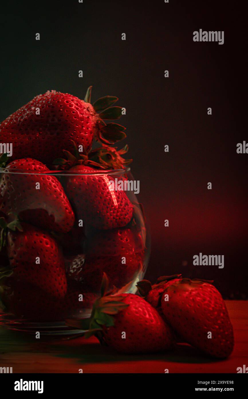 Primo piano di fragole fresche in una ciotola su un tavolo di legno Foto Stock