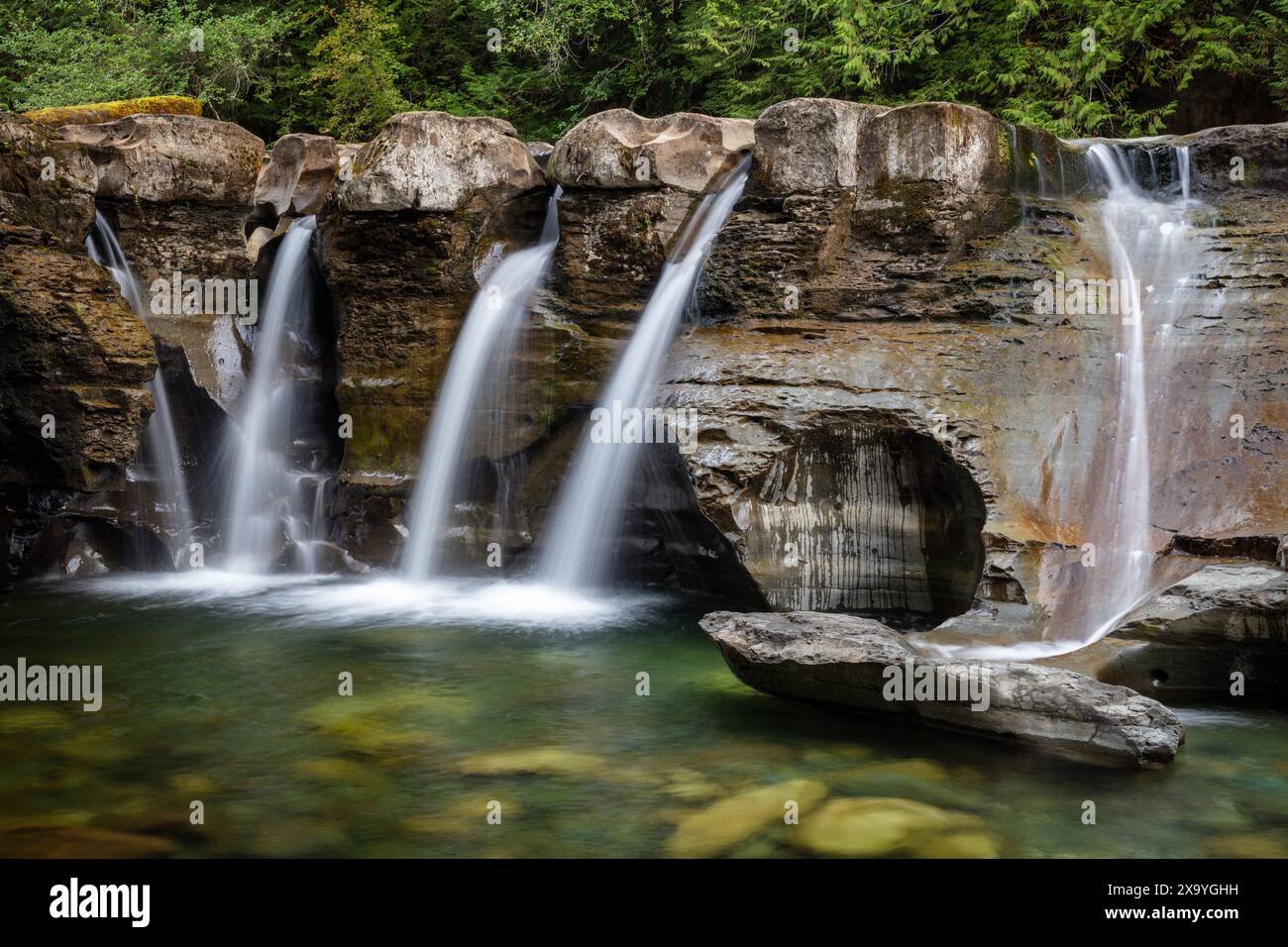 Le cascate d'acqua si estendono su rocce con piccole cascate all'interno della Comox Valley. Foto Stock